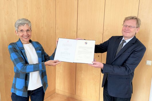Rektor Christoph Niemand überreicht Professorin Susanne Gillmayr-Bucher die Ernennungsurkunden.