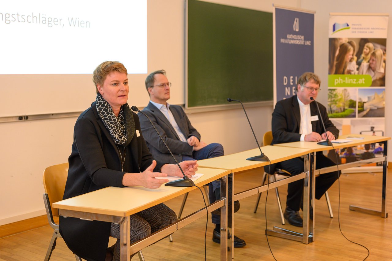 Univ.-Prof.in Dr.in Ines Weber mit Univ.-Prof. Dr. Markus Hengstschläger und Diözesanbischof Dr. Manfred Scheuer am Podium.