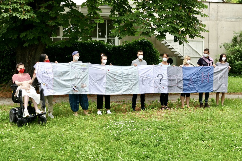 Workshop im Rahmen von Im Vorbeigehen II/19. Die Workshop-Teilnehmer*innen präsentieren ihr fertiges Werkstück DAHOAM.