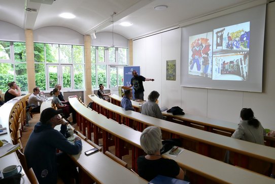 Wissenschaftler:innen und Forscher:innen im Hörsaal der KU Linz.