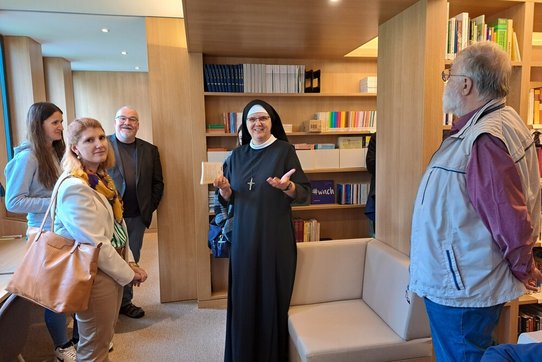 Priorin Sr. Dr.in Magdalena Niescioruk OSB führt durch die Bibliothek der Benediktinerinnen der Anbetung in Wien.