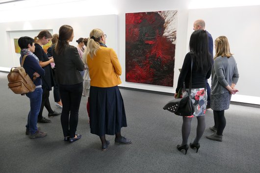 KU Studierende vor einem der bearbeiteten Werke der Kunstsammlung der RLB: Hermann Nitsch, "ohne Titel", 2015, Öl auf Leinwand, 150 x 200 cm.