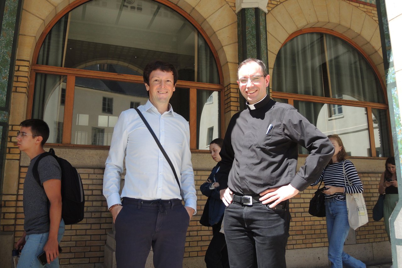Picture of Andreas Schmoller with a priest in front of a building