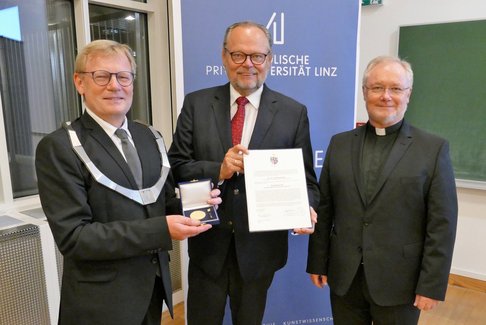 Verleihung der Würde eines Ehrensenators an Gen.-Dir. a.D. Dr. Josef Stockinger. Von li: Rektor Univ.-Prof. Dr. Christoph Niemand, Gen.-Dir. a.D. Dr. Josef Stockinger, Generalvikar Univ.-Prof. DDr. Lederhilger OPraem. © KU Linz/Hermine Eder.