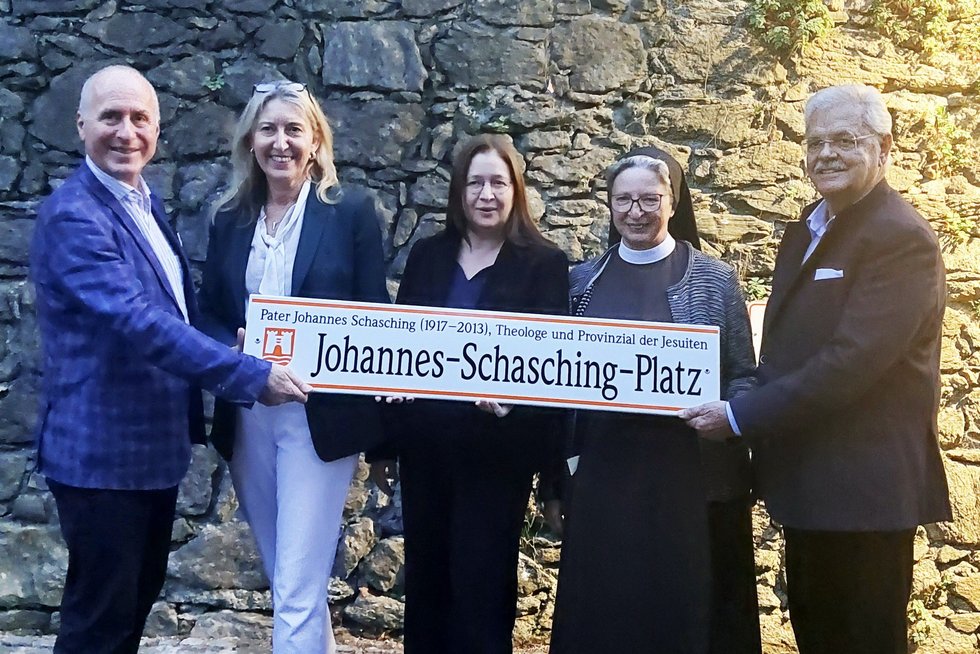 Initiatoren und Ehrengäste mit dem Straßenschild "Johannes Schasching Platz".