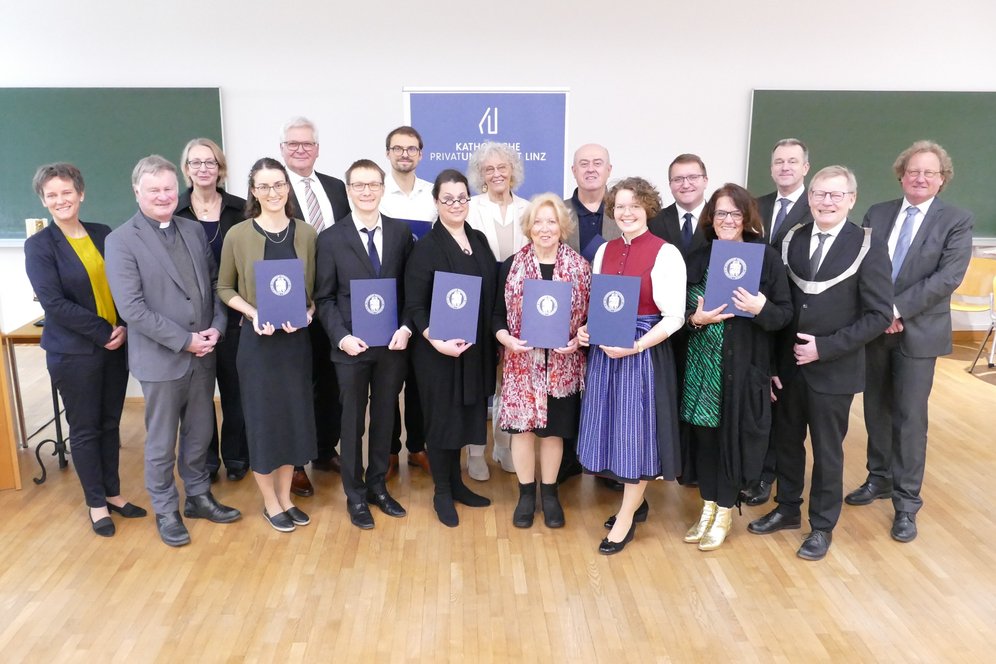Verleihung von akademischen Graden an der KU Linz. © KU Linz/Eder. Die Absolventinnen und Absolventen mit Bischof, Rektor, Vizerektorin und Studiendekanin im H1 der KU Linz.