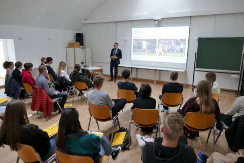 Ass.-Prof. Florian Wegscheider referierte aus dem Bereich Liturgiewissenschaft zum Thema "Zwischen Ronaldo und Papst". © KU Linz / Hermine Eder. Florian Wegscheider referiert vor zahlreichen Schüler:innen im Hörsaal 5 der KU Linz.