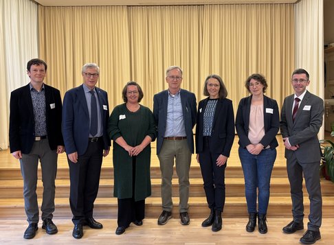 Gruppenbild von Referent:innen vor Bühne