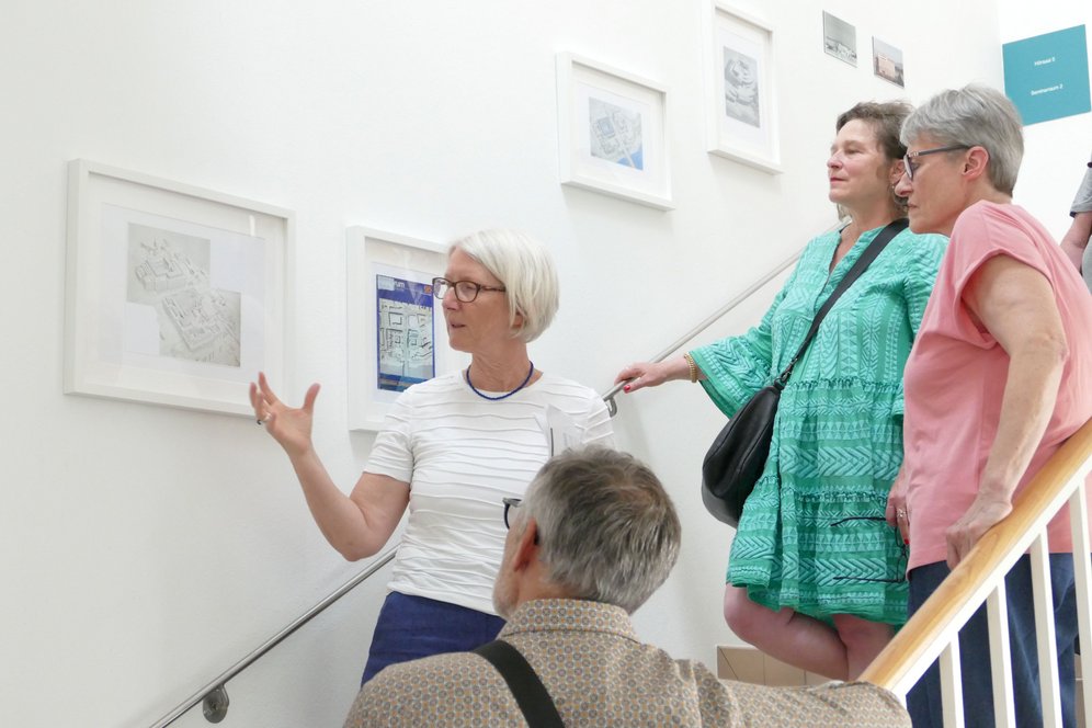 Foto: KU Linz/Reinhard Kren. Im Stiegenhaus des Altbaus werden im Rahmen der Ausstellung "Ungebautes Linz" im Sommersemester 2026 Linzer "Brückenkopfprojekte" vorgestellt.